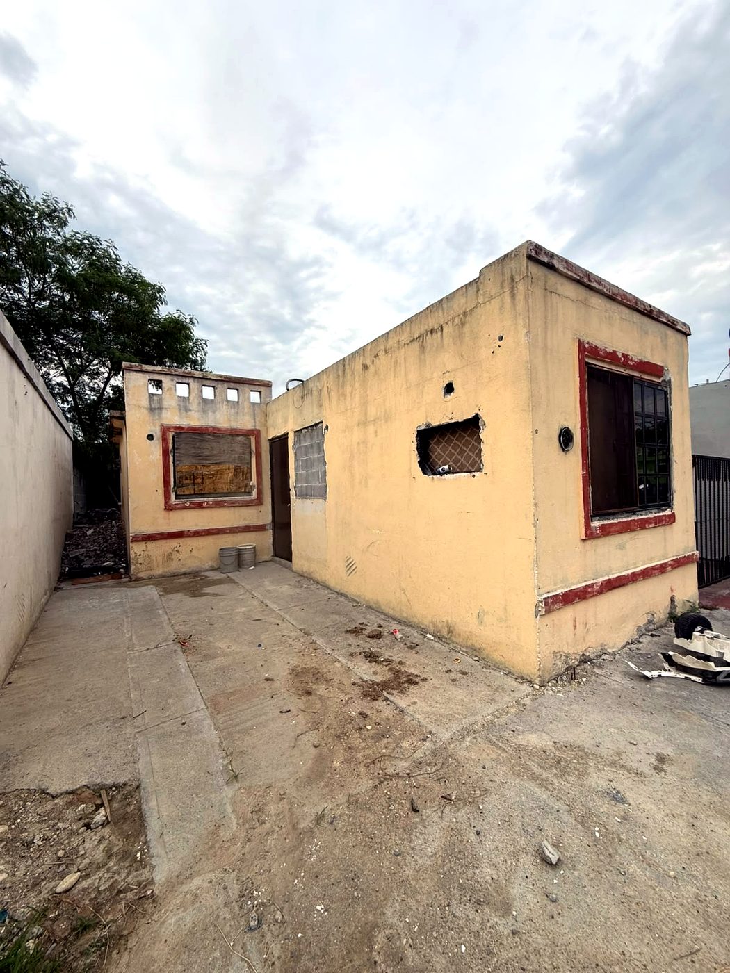 Casa antes de la remodelación de CasaLista, con daños en fachada y ventanas